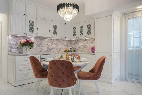 a kitchen with a table and chairs and a chandelier at ЛУКС НА МОРЕ Luxury apartment in downtown with garage in Varna City