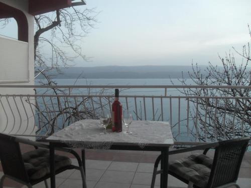 a table with a bottle of wine and two glasses at Apartments Coko in Omiš