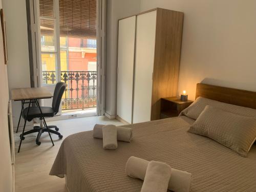 1 dormitorio con cama, escritorio y ventana en Rest Valencia en Valencia