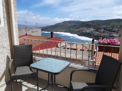 a table and chairs on a balcony with a view of the ocean at Bellagio in Castelsardo