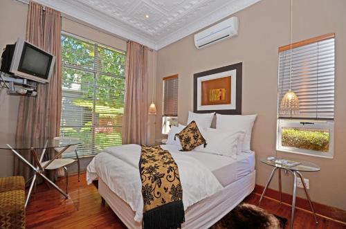 a bedroom with a bed and a television in it at Saffron Guest House in Johannesburg