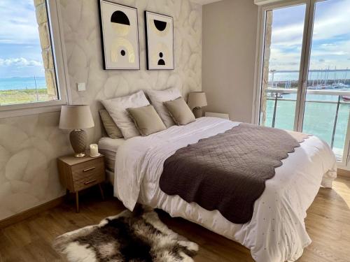 - une chambre avec un grand lit et une vue sur l'océan dans l'établissement Appt Vue Mer Exceptionnelle Triple Expo - 70m 2ch - Rénové, à Saint-Cast-le-Guildo
