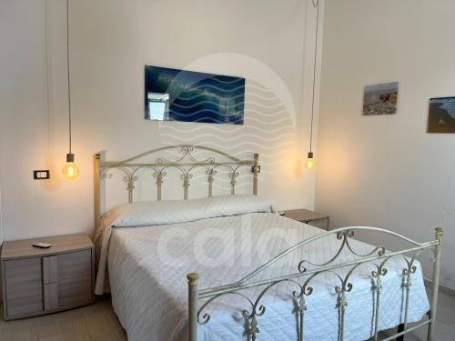 ein Schlafzimmer mit einem Bett mit einer weißen Tagesdecke in der Unterkunft Villino Mediterraneo n°1 in Porto Cesareo