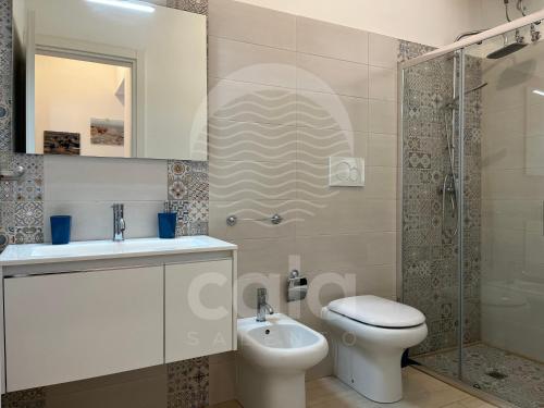 ein Bad mit einem WC, einem Waschbecken und einer Dusche in der Unterkunft Villino Mediterraneo n°1 in Porto Cesareo