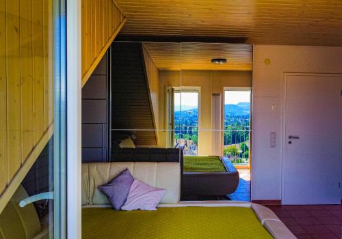 a view of a room with a bed and a balcony at Panoramahaus am Schlipfweg in Weil am Rhein