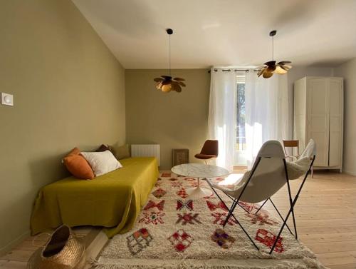 a living room with a bed and a table at L’appartement 39 in Lons-le-Saunier