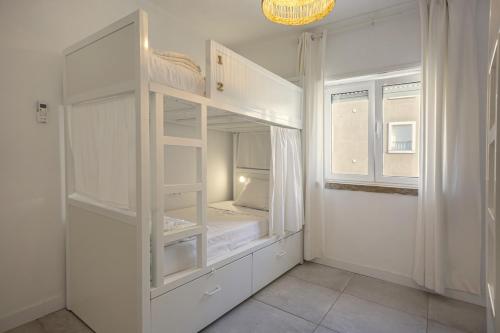 a white room with a bunk bed in it at Sun Lovers Hostel in Albufeira