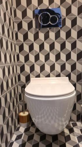 La salle de bains est pourvue de toilettes dans un mur en damier. dans l'établissement Modern Guy Moquet CityCosy, à Paris