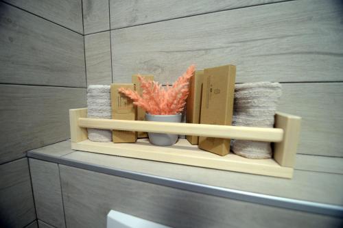 a shelf in a bathroom with a vase and towels at Apartmani Čarolija in Lučani