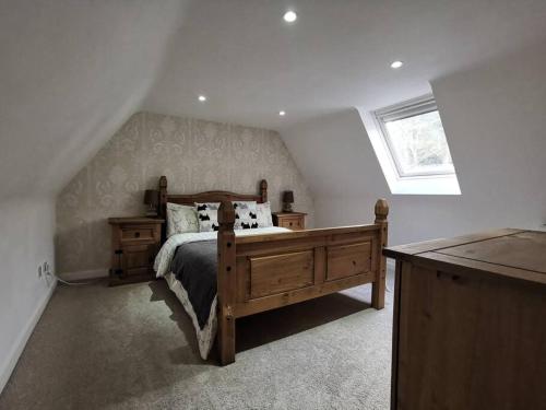 1 dormitorio con cama de madera y ventana en Historic cottage next to loch lomond Luss en Alexandria