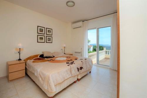 1 dormitorio con 1 cama grande y balcón en Villa Carrera 4 Bedrooms, en Fanals d'Aro