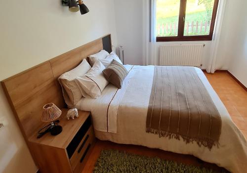 a bedroom with a large bed with a wooden headboard at Chalet sobre playa canelas, EN SANXENXO in Sanxenxo