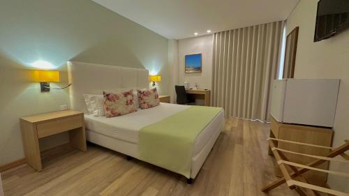 a hotel room with a bed and a television at Sea Garden Peniche in Peniche