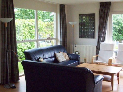 a living room with a black leather couch and a table at Ark in Terherne