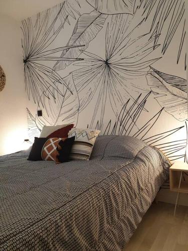 - une chambre avec un lit orné d'une fresque murale dans l'établissement Anglet Biarritz Appartement avec piscine, à Anglet