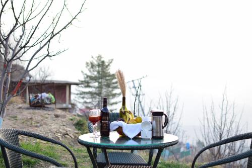 a table with a bottle of wine and a basket of bananas at Crested View Kufri -Orchard Villa in Kūfrī