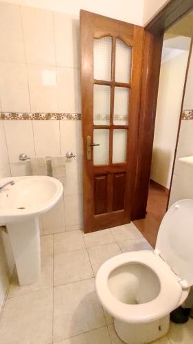 a bathroom with a toilet and a sink at Apartamento acolhedor com vista para o Monte Cara in Mindelo