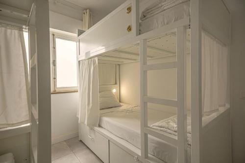 a white bunk bed in a room with a window at Sun Lovers Hostel in Albufeira