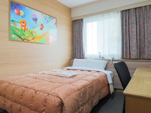 a bedroom with a bed and a desk and a window at Hotel Maira in Okayama