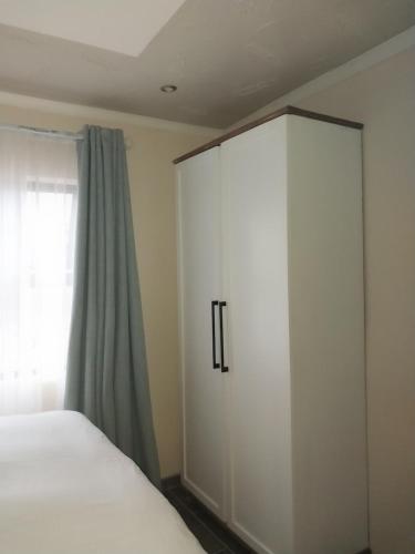 a bedroom with a white cabinet next to a window at Seqonoka Villa Accommodation & Events Park in Berea Hills