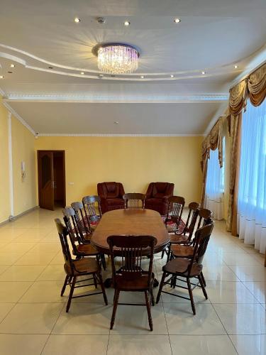 a dining room with a table and chairs and a chandelier at Готель МАГНАТ in Sutysky