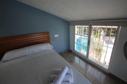 um quarto com uma cama e uma grande janela em Casa La Noria by Rental Olé em Múrcia