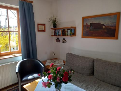 a living room with a couch and a table with flowers at Ferienwohnung Am Wieh in Harsefeld