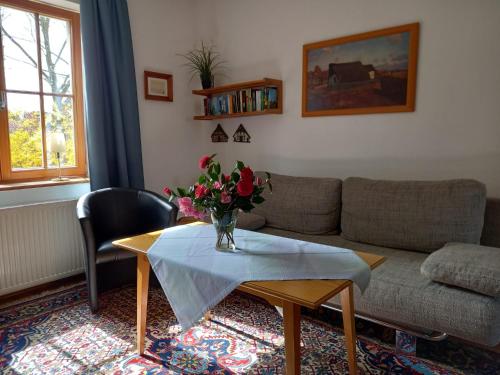 a living room with a table with a vase of flowers on it at Ferienwohnung Am Wieh in Harsefeld