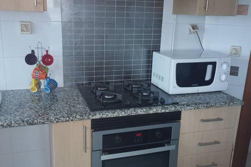 a kitchen with a stove and a microwave at Cosy and Charming Apartment close to TUNISIA MALL Lac2 Tunis in Tunis