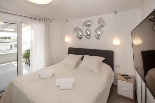 a bedroom with a white bed with two white pillows at Sea view penthouse in Vari in Vari