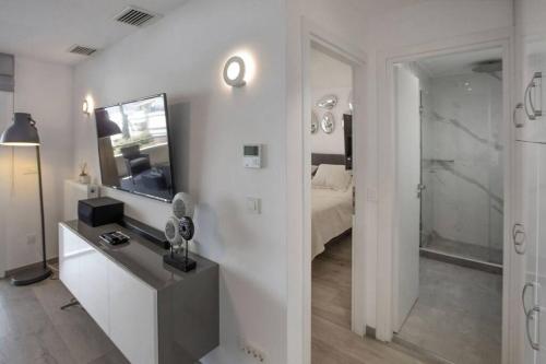 a white bedroom with a bed and a mirror at Sea view penthouse in Vari in Vari