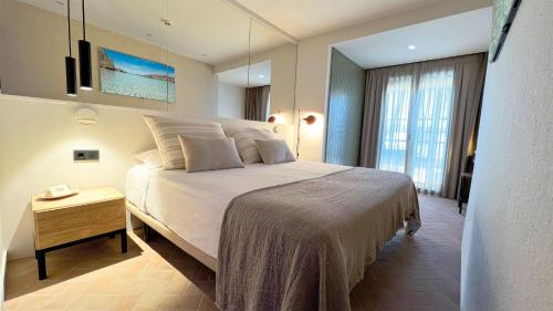 1 dormitorio con 1 cama blanca grande en una habitación en Hostal Olga, en Sant Antoni de Calonge