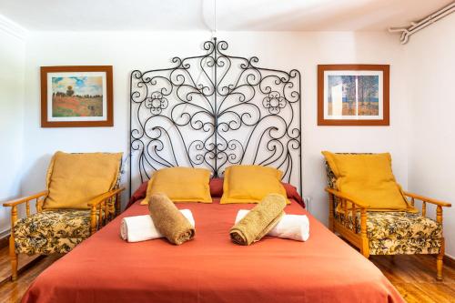 a bedroom with a large bed with two chairs at Villa Florida in Fornalutx