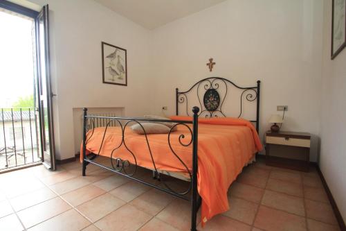 sypialnia z łóżkiem z pomarańczowym kocem w obiekcie Hotel La Quiete w Asyżu