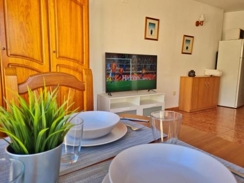 un salon avec une table et une télévision dans l'établissement Apartamento 64F, à Malaga