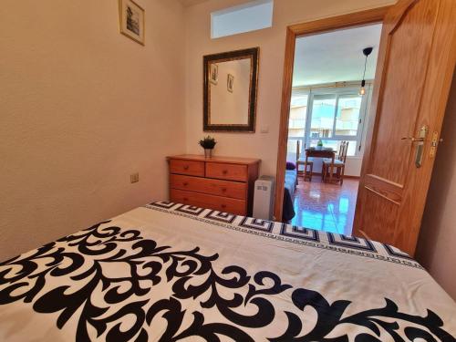 - une chambre avec un lit et une couette noire et blanche dans l'établissement Apartamento 64F, à Malaga