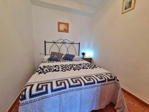 - une chambre dotée d'un lit avec une couverture bleue et blanche dans l'établissement Apartamento 64F, à Malaga