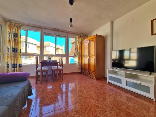 - un salon avec un canapé, une télévision et une table dans l'établissement Apartamento 64F, à Malaga