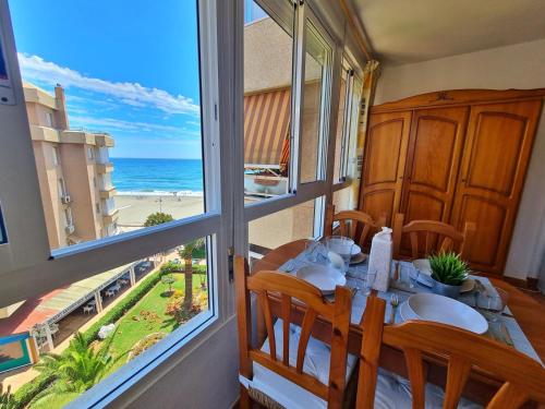 - une salle à manger avec une table et une vue sur l'océan dans l'établissement Apartamento 64F, à Malaga