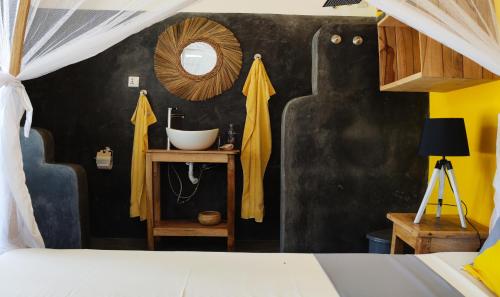 Schlafzimmer mit einem Bett und einem Spiegel in der Unterkunft Princess of Zanzibar in Michamvi