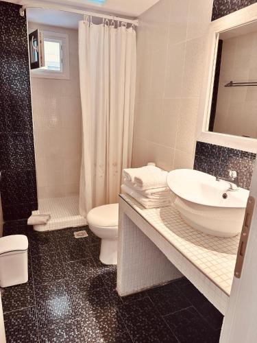 a bathroom with a sink and a toilet and a shower at Phoenix in Fira