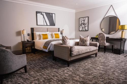 1 dormitorio con cama, silla y espejo en Golden Horse Hotel, 