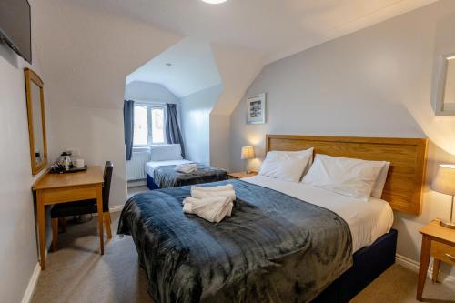 a hotel room with a large bed and a desk at The Angel Hotel in Alton
