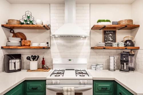 a kitchen with green cabinets and a white stove at Red Rock Falls Cabin, 8 miles from Yosemite South Gate, with trailhead, Game Room and HotTub in Oakhurst