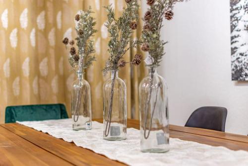 four glass vases with flowers in them on a table at Red Rock Falls Cabin, 8 miles from Yosemite South Gate, with trailhead, Game Room and HotTub in Oakhurst