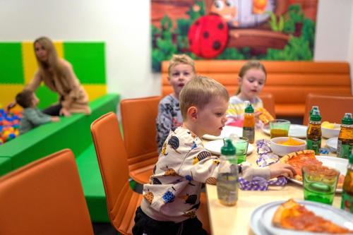 a group of children sitting at a table eating food at Hotel Smetanova in Vsetín
