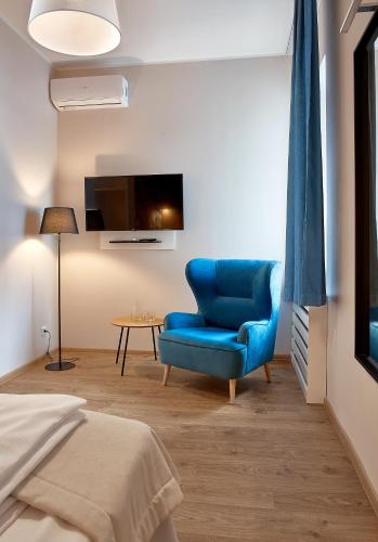 a bedroom with a blue chair and a table at Hotel Traffic Poznań Stare Miasto in Poznań