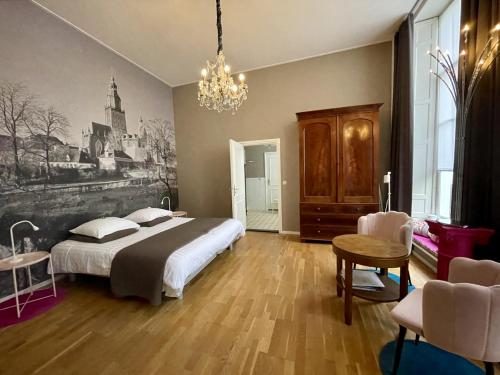 a bedroom with a large bed and a chandelier at Kerkstraatje3 in Zutphen