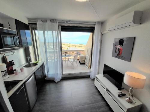 une petite cuisine avec vue sur un balcon dans l'établissement Studio Village Naturiste Baby Doll, au Cap d'Agde