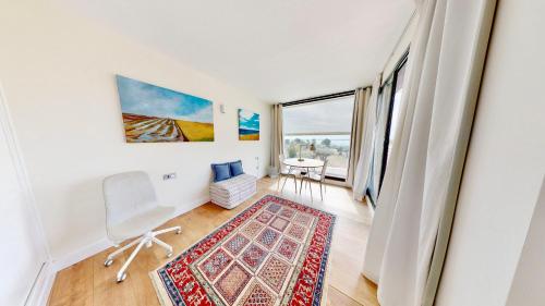 a living room with a window and a chair and a rug at Villa Lili in L'Ampolla